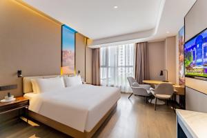 a hotel room with a bed and a desk at Mercure Huhhot Economic Zone in Hohhot