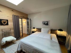 a bedroom with a large white bed and two lamps at Winklern Lodges in Kitzbühel
