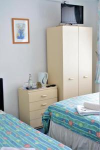 a bedroom with a dresser and a bed and a cabinet at Holiday Plus - 50 Palatine Road in Blackpool
