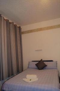 a room with a bed with a hat on it at Holiday Plus - 50 Palatine Road in Blackpool +2 photos