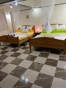 - 2 lits dans une chambre avec un sol en damier dans l'établissement Das Haus am Meer, à Port Safaga