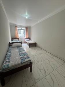 a room with two beds and a couch in it at Casa para até 8 pessoas perto da Basílica in Aparecida