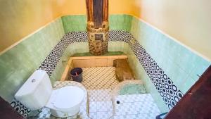 a small bathroom with a toilet in a room at Sumatra Cheeky Monkeys in Bukit Lawang