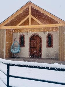 een huis bedekt met sneeuw met een blauwe deur bij Chalet Harmony in Bagdatʼi