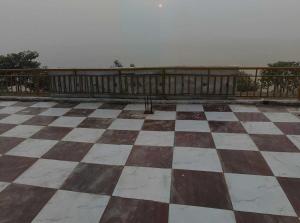 an empty balcony with a checkerboard floor at Hotel O Lake Side Inn in Gorakhpur