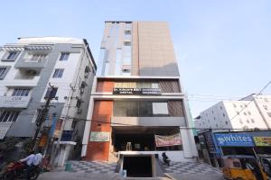 a tall building on a city street with buildings at Hotel Qualia Oak in Hyderabad
