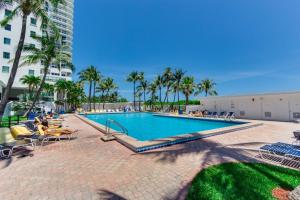 una piscina con palmeras y un edificio en Oceanfront Studio Casablanca Miami Beach, en Miami Beach