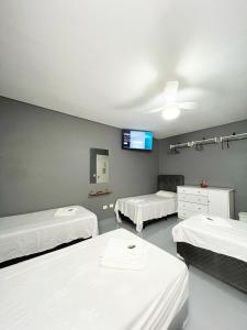 Cette chambre comprend 3 lits et une télévision murale. dans l'établissement Hostel Anprado #6, à Guarulhos 21 autres photos