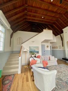 un soggiorno con un divano bianco e una scala di Convent Franklin - Schoolhouse Apartment a Franklin