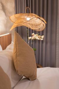 a chandelier hanging over a bed with a pillow at Kaiarasa Villas and Suite in Canggu