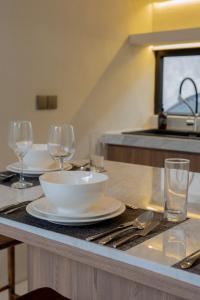 a table with a bowl and wine glasses on it at Kaiarasa Villas and Suite in Canggu