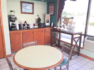 a coffee shop with a table and a table and chairs at Economy Inn Dillon in Dillon