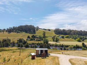 a small house on a hill next to a dirt road at Perrys South by Tiny Away in Forth