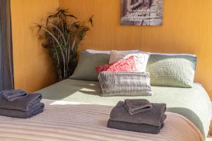 a bed with towels and pillows on top of it at Perrys South by Tiny Away in Forth