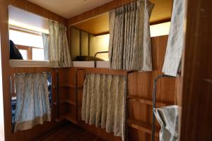 een kleine kamer met 2 ramen en een bed bij Joeys Hostel Manali in Manāli