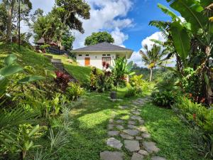 a garden path leading to a white house at A Calm Spacious Cottage with Mount Agung View in Selat