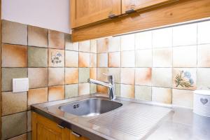 Il dispose d'une cuisine avec un évier et un mur carrelé. dans l'établissement Appartement Valmorel, à Valmorel 17 autres photos