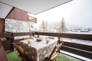 une table et des chaises sur un balcon avec vue dans l'établissement Appartement Valmorel, à Valmorel