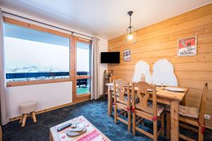 une salle à manger avec une table et une grande fenêtre dans l'établissement Appartement Valmorel, à Valmorel