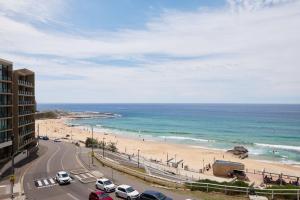 a view of a beach with cars parked on the road at The Outlook in Newcastle