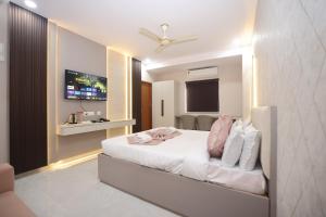 a bedroom with a white bed with a ceiling fan at Hotel Qualia Oak in Hyderabad