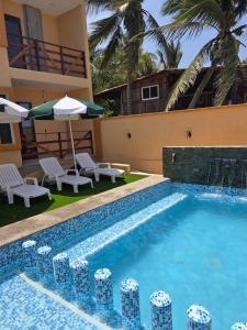een zwembad met stoelen en parasols naast een gebouw bij Bello Atardecer in Papanoa