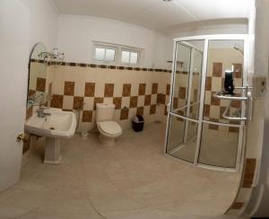 een badkamer met een douche, een toilet en een wastafel bij Trillium Villa in Nuwara Eliya