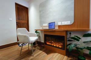 a living room with a fireplace and a laptop on a desk at Joeys Hostel Manali in Manāli