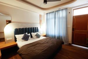 a bedroom with a large bed with pillows on it at Joeys Hostel Manali in Manāli