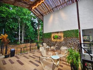 un patio avec des chaises et un mur en pierre dans l'établissement Borneo Nature Lodge 2, à Kinabatangan 25 autres photos