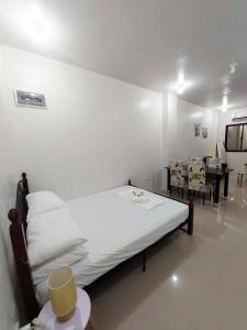 une chambre avec un lit, une table et des chaises dans l'établissement JLG Transient Home Pagsanjan Laguna, à Pagsanjan