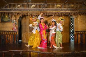 a group of girls in colorful costumes on a stage at River Kwai Jungle Rafts in Sai Yok