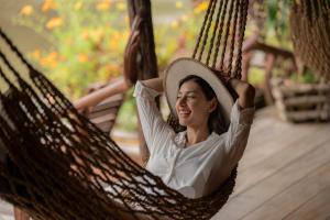 een vrouw in een hangmat met een hoed op bij River Kwai Jungle Rafts in Sai Yok
