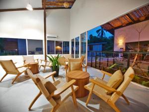 un patio avec des chaises et des tables et une grande fenêtre dans l'établissement Borneo Nature Lodge 2, à Kinabatangan