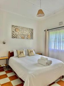 een wit bed in een kamer met een raam bij Lion Hill Place in Nakuru