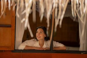 een vrouw die uit een raam kijkt bij River Kwai Jungle Rafts in Sai Yok