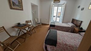 a room with two beds and a table and chairs at Alojamiento Oviedo 1 in Oviedo +14 photos