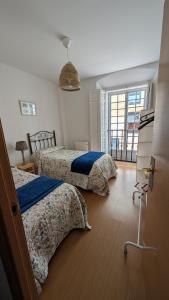 een slaapkamer met twee bedden en een raam bij Alojamiento Oviedo 1 in Oviedo