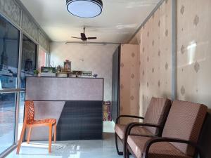 une chambre avec deux chaises et un grand écran dans l'établissement Guru Residency Pondicherry, à Pondichéry