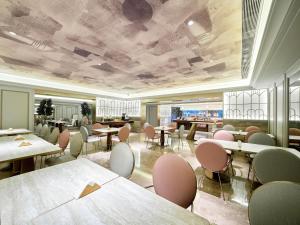 a waiting room with tables and chairs and tablesktop at Mercure Beijing Universal Resort in Beijing