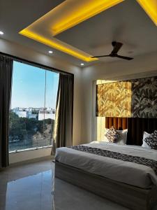 een slaapkamer met een groot bed en een groot raam bij Hotel La Serene in Agra