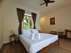 a bedroom with a bed with two white shoes on it at Borneo Nature Lodge 2 in Kinabatangan