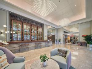 a lobby with two chairs and a table at Mercure Beijing Universal Resort in Beijing
