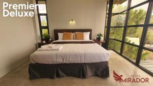 ein Schlafzimmer mit einem großen Bett und einem großen Fenster in der Unterkunft Hotel Mirador in Baguio City