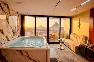 een kamer met een bad en uitzicht op de piramides bij Zoom Pyramids View inn in Caïro