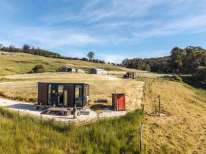 a small house on top of a grassy hill at Perrys North by Tiny Away in Forth