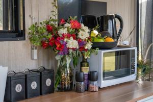 a vase of flowers sitting on top of a microwave at Perrys North by Tiny Away in Forth
