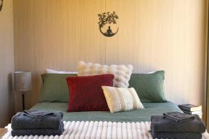 a bed with red and green pillows on it at Perrys North by Tiny Away in Forth