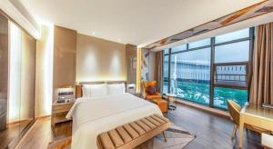 een slaapkamer met een groot bed en een groot raam bij Tomeet Hotel in Meizhou +257 foto's