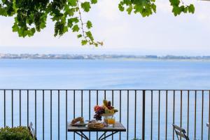 un tavolo con un piatto di frutta e un piatto di cibo di Hotel Henry's House a Siracusa